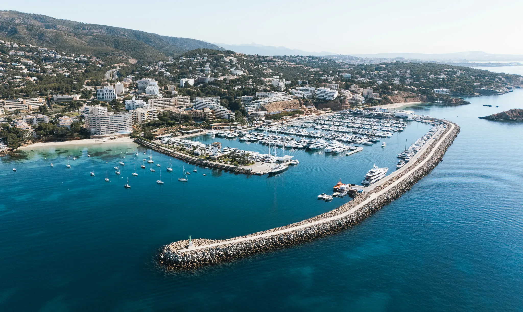 Vue aérienne de Puerto Portals à Majorque, où se trouvent les bureaux de Nautic Luis, montrant le port de plaisance, les amarres et l'environnement côtier.