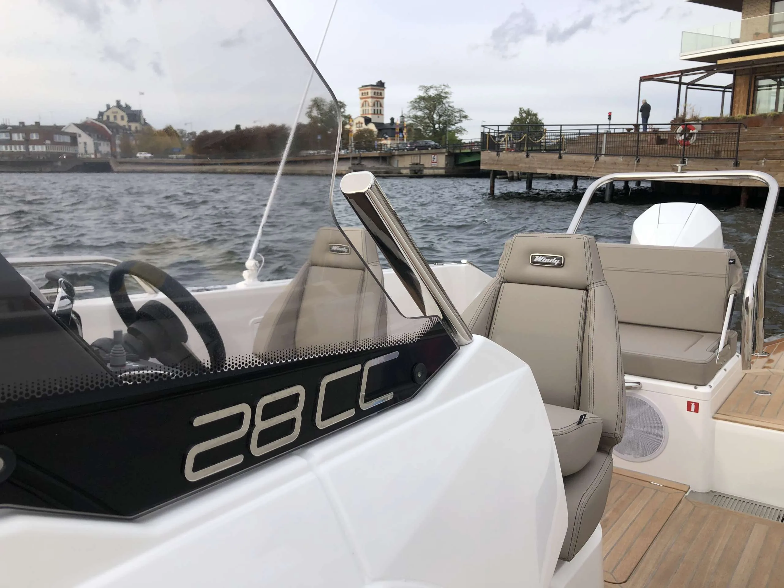 Windy SR 60, exterior view of the console with steering wheel, windshield, seats and aft deck next to the dock.