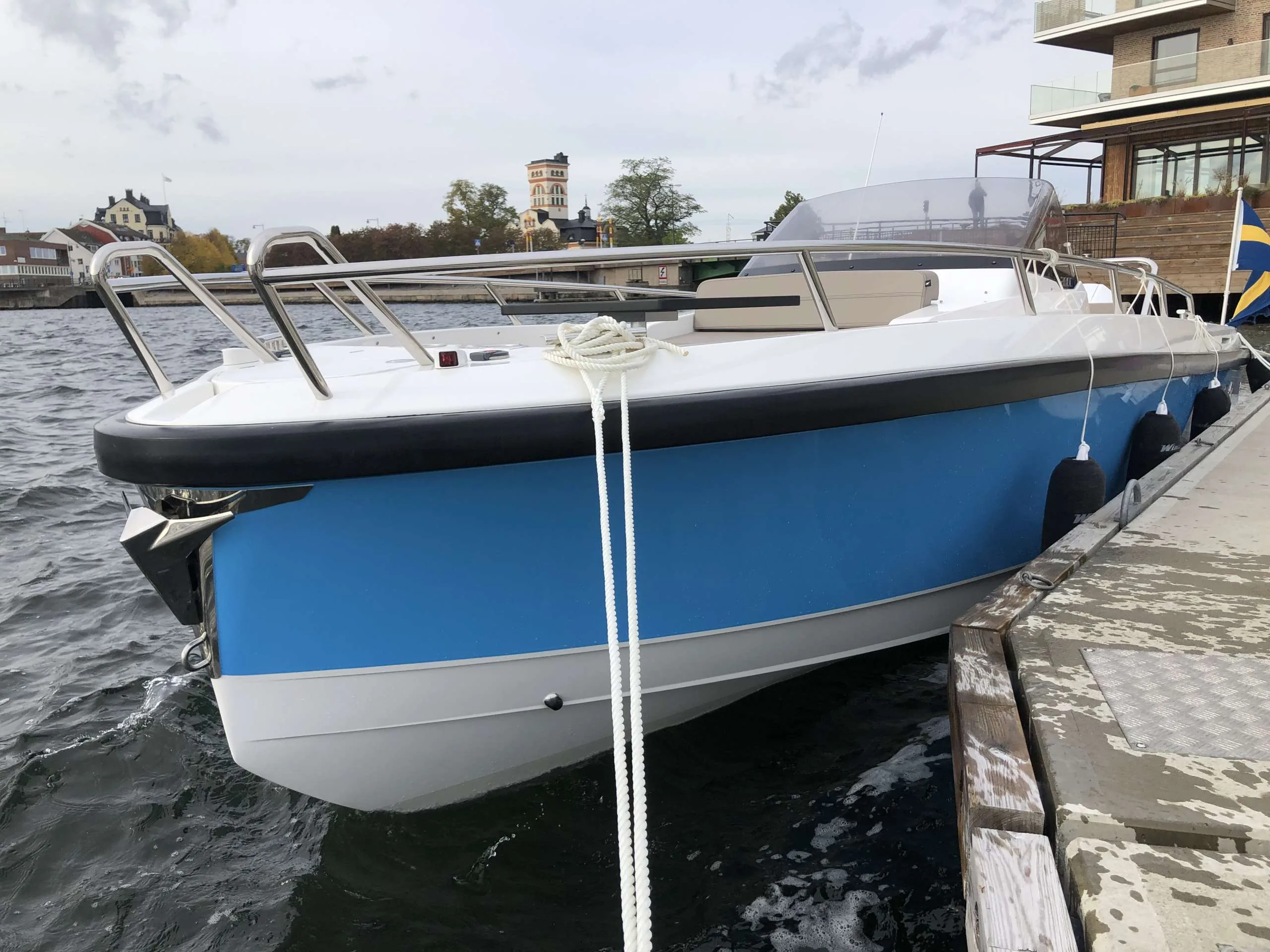 Windy SR 60 exterior side view, moored to a dock, with center console, windshield and mooring lines.