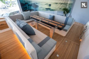 Interior del Windy SR44 Blackhawk, salón con sofás en U, mesa central y ventanales panorámicos.