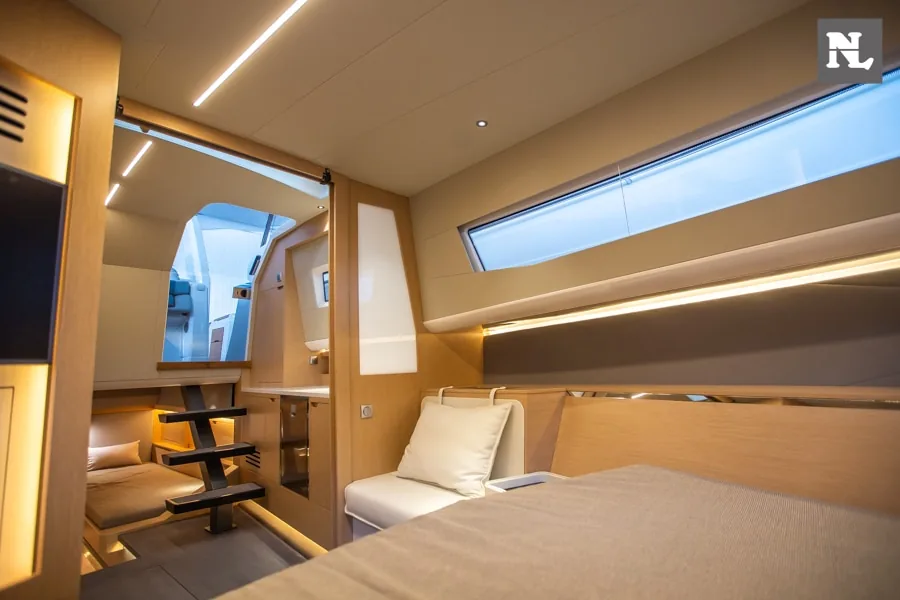 Interior del Windy SR44 Blackhawk: camarote con cama, sofá, escalera y ventanales laterales.