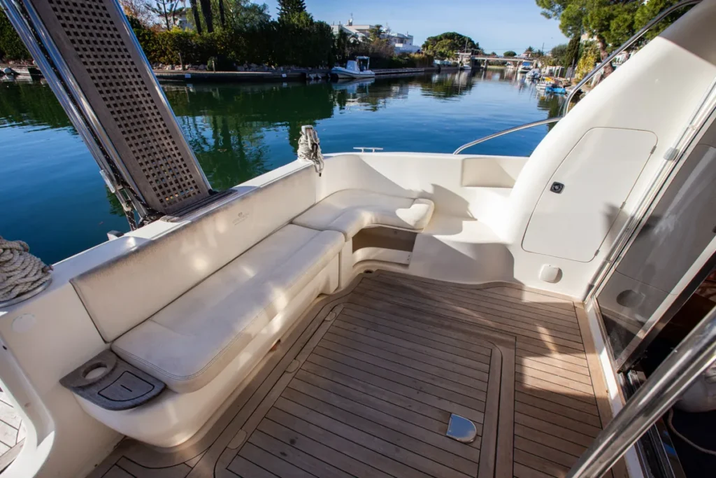 Achtercockpit der gebrauchten Cranchi Atlantique 40 in Empuriabrava – Nautic Luis, Seitenansicht mit einem L-förmigen Sofa und Teakboden