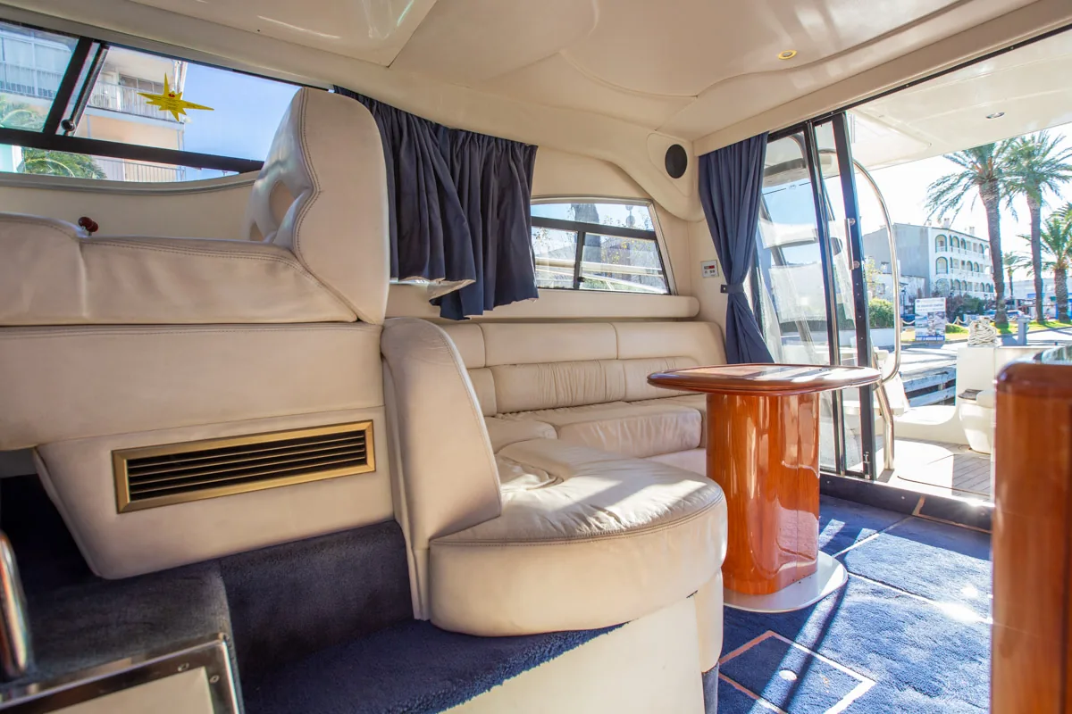 Cranchi Atlantique 40 – Salón interior vista entrada Innenbereich der gebrauchten Cranchi Atlantique 40 in Empuriabrava – Nautic Luis, mit Ecksofa und Holztisch neben dem Eingang