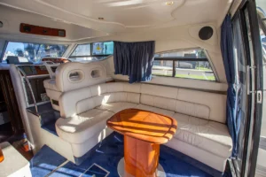 Hauptsalon der gebrauchten Cranchi Atlantique 40 in Empuriabrava – Nautic Luis, mit umlaufendem Sofa und zentralem Holztisch
