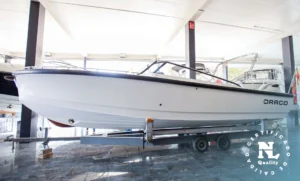 Draco 27 RS visto de costado sobre remolque, en exposición náutica interior.