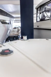 Draco 27 RS, primer plano de la cubierta de proa exterior con herrajes y embarcaciones al fondo