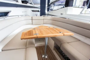 Draco 27 RS: interior de proa abierta con mesa de madera y asientos tapizados en U
