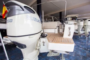Popa del Draco 27 R Sport con motor fueraborda Suzuki, plataforma de baño y puesto de mando.