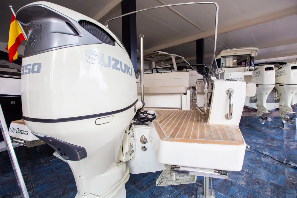 Popa del Draco 27 R Sport con motor fueraborda Suzuki, plataforma de baño y puesto de mando.