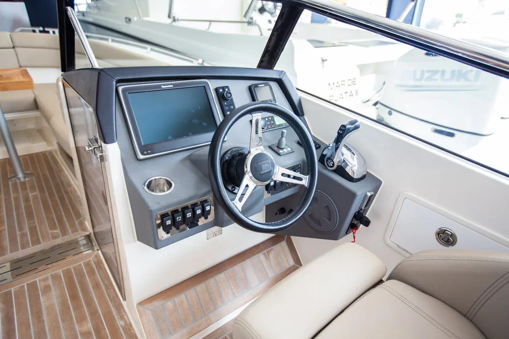Puesto de mando interior del Draco 27 RSport, con volante, pantalla, controles, instrumentación y asientos.