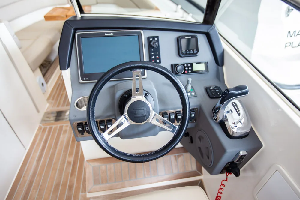 Puesto de pilotaje interior del Draco 27 RSport, con volante, pantallas, controles y palanca de aceleración.