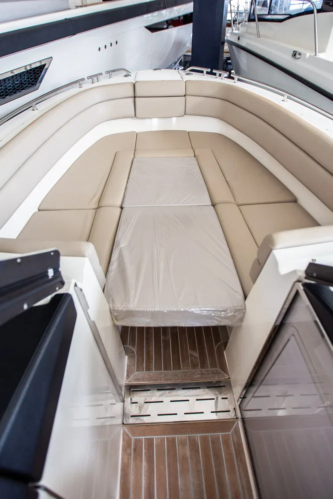 Draco 27 R-Sport: proa exterior vista desde atrás, con solárium acolchado y suelo de teca.