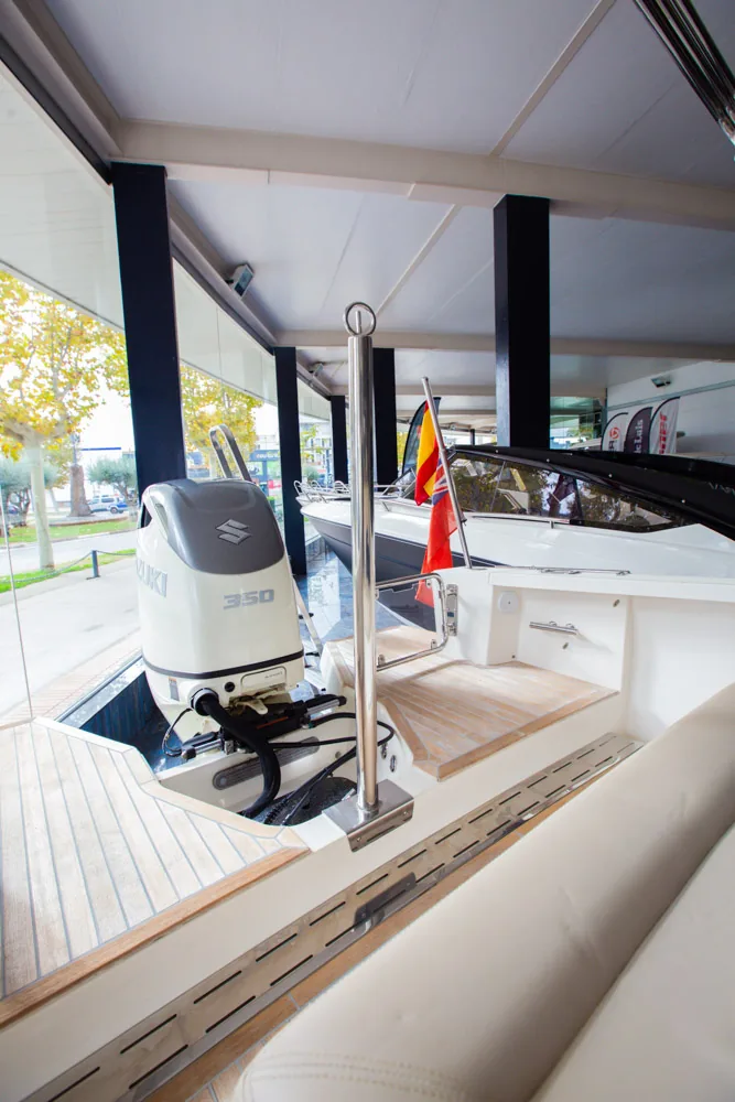 Draco 27 RS, vista de popa del cockpit con motor fueraborda, banderas y bancos laterales.