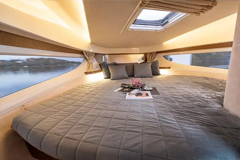 Interior del Marex 330 Scandinavia con cama doble, ventanas laterales y tragaluz superior.