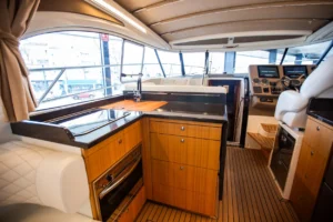 Intérieur du Marex 360 Cabriolet Cruiser, vue sur la cuisine et le poste de pilotage, avec des placards et des sièges.