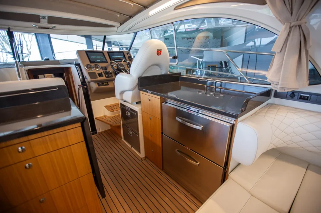 Intérieur du Marex 360 Cabriolet Cruiser, vue vers le poste de pilotage, la cuisine et le salon avec des sièges capitonnés.