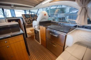 Intérieur du Marex 360 Cabriolet Cruiser, vue vers le poste de pilotage, la cuisine et le salon avec des sièges capitonnés.