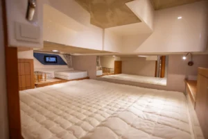 Intérieur de la cabine du Marex 360 Cabriolet Cruiser, avec un lit double, un matelas rembourré et des placards blancs.