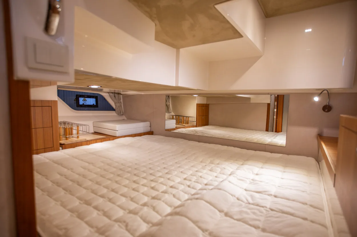 Buddy_M360-26 Intérieur de la cabine du Marex 360 Cabriolet Cruiser, avec un lit double, un matelas rembourré et des placards blancs.