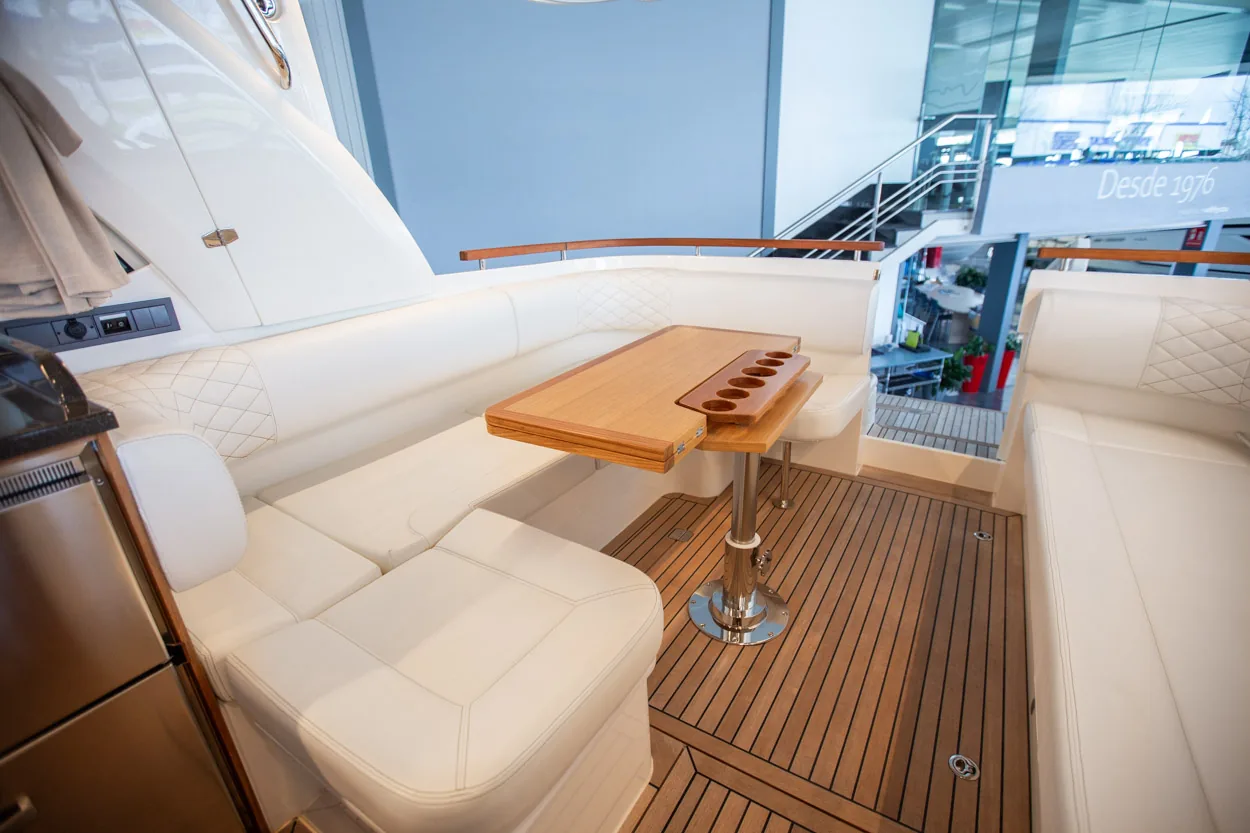 Buddy_M360-8 Intérieur du Marex 360 Cabriolet Cruiser, salon avec canapés, table en bois et plancher en teck vu depuis la proue