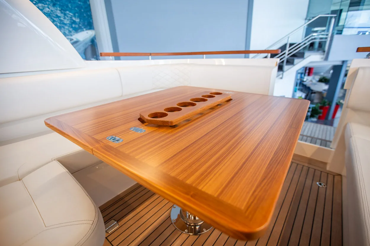 Buddy_M360-9 Intérieur du Marex 360 Cabriolet Cruiser, table en bois avec pied central et sièges rembourrés dans le cockpit.