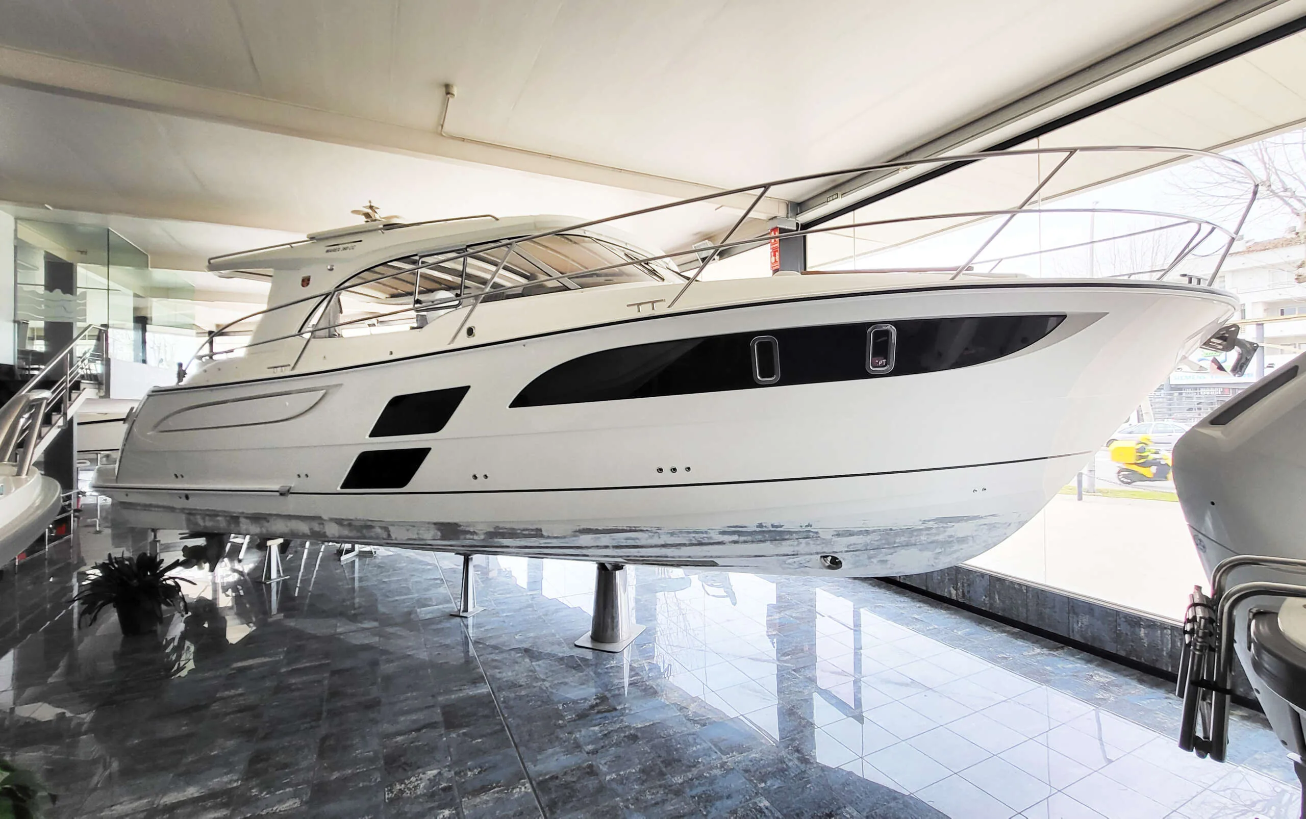 Buddy_M360 EXTERIOR Marex 360 Cabriolet Cruiser d’occasion vu de profil lors d’une exposition nautique, sur des supports.