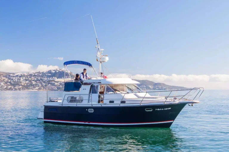Nimbus 380 Commander vu de profil sur l’eau, avec une cabine, un pont, des antennes et une personne à bord