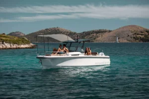 Nimbus T8 Taupé visto de perfil en el exterior, con pasajeros a bordo y montañas al fondo