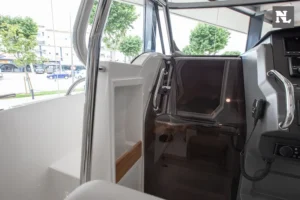 Interior del Nimbus T8 Taupé, vista del acceso lateral con puerta acristalada, consola y asientos.