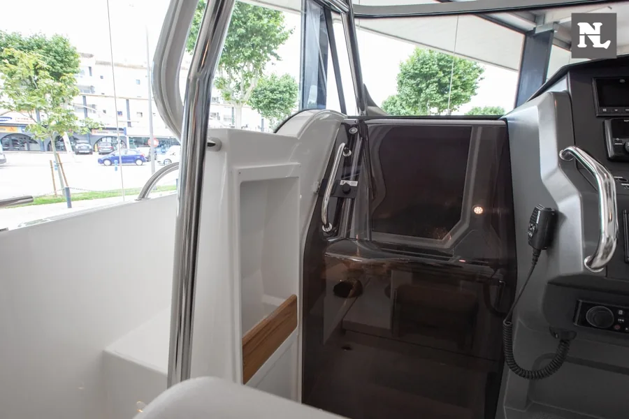 Interior del Nimbus T8 Taupé, vista del acceso lateral con puerta acristalada, consola y asientos.