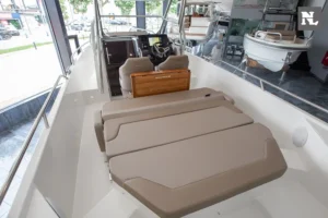 Interior del Nimbus T8 Taupe visto desde popa, con solárium delantero, puesto de mando y parabrisas.