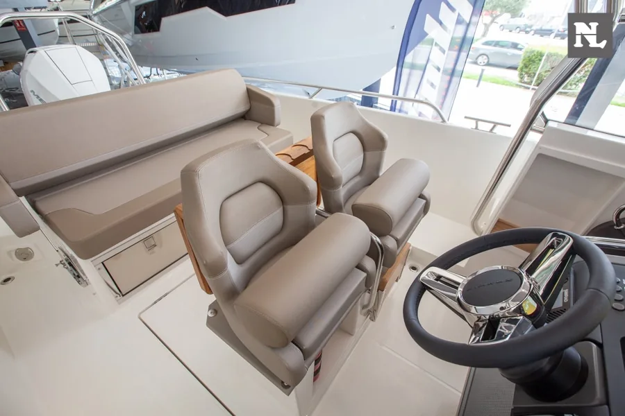 Interior de la Nimbus T8 con dos asientos de mando, volante, consola y banco trasero tapizado.