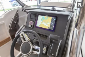 Consola de mando interior del Nimbus T8, con volante, pantallas de navegación, controles y parabrisas.