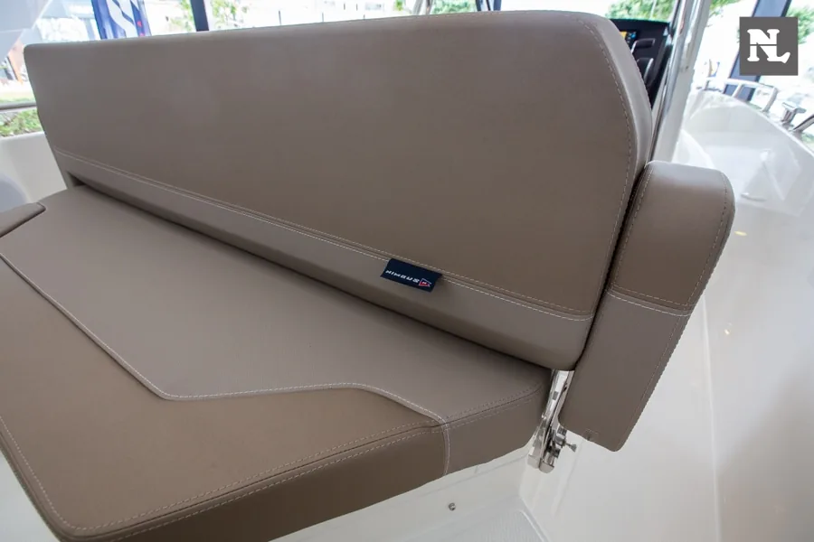 Asiento acolchado color topo del interior del barco Nimbus T8, visto en primer plano con respaldo abatible.