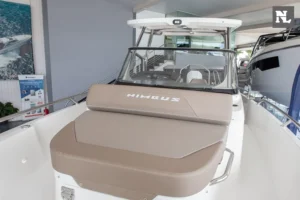 Exterior frontal del barco Nimbus T8, con solárium tapizado taupe, parabrisas, consola de mando y techo rígido.