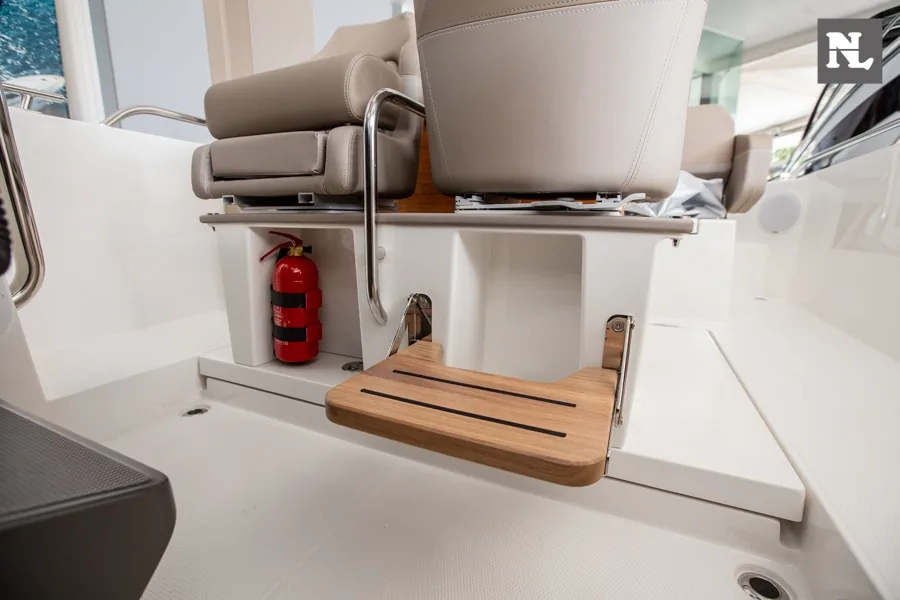 Interior de la Nimbus T8 con asientos tapizados, escalón de madera y extintor rojo visible.