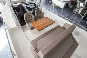 Interior de la Nimbus T8 visto desde arriba, con puesto de mando, asientos, mesa de madera y sofá en U.