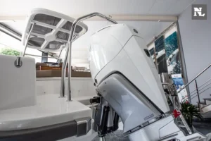 Popa del Nimbus T8 con motor fueraborda, plataforma de baño y puesto de gobierno visibles desde el interior.