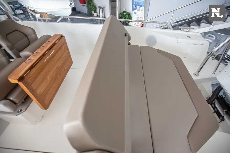 Interior de la Nimbus T8, vista del salón con asientos tapizados en taupe y mesa abatible de madera.