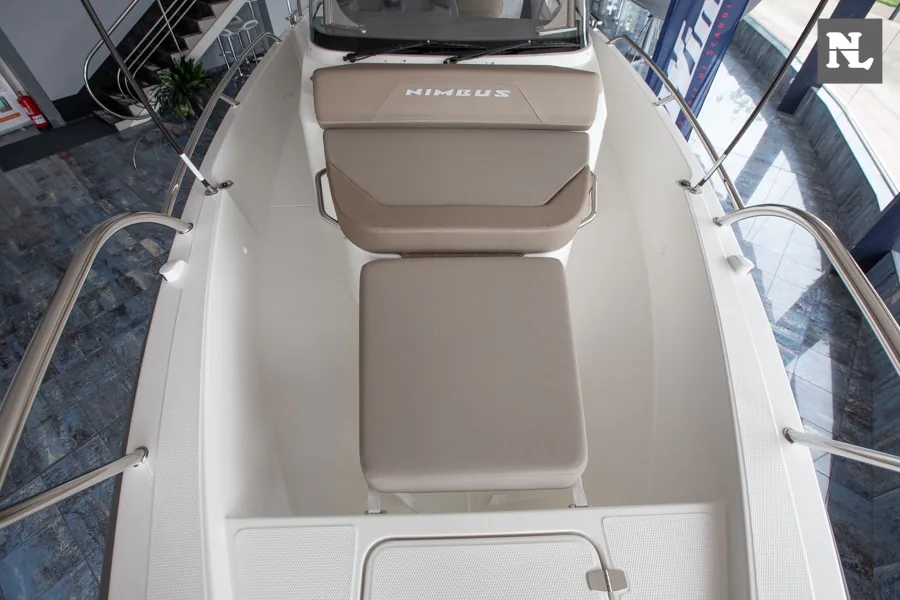 Interior de la Nimbus T8 con asientos tapizados color topo, pasillo central y barandillas laterales.