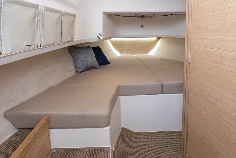 Innenraum der Nimbus T9 mit Doppelbett, Kissen, Hängeschränken und Seiteneinstieg.