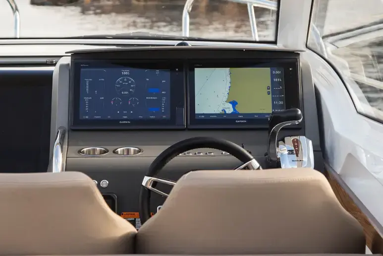 Interior del Nimbus W9: puesto de mando con volante, doble pantalla Garmin y controles, visto desde popa.