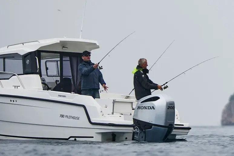 Exterior del Parker 700 Pilothouse con dos pescadores y motor fueraborda Honda 200.