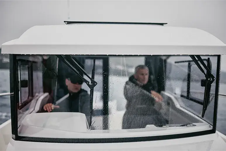 Parker 700 Pilothouse, vista frontal de la cabina con dos personas y parabrisas con limpiaparabrisas.