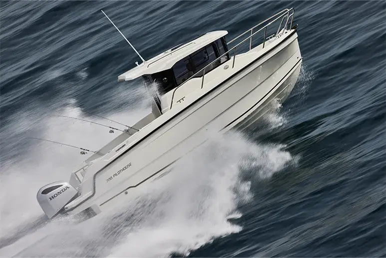 Parker 700 Pilothouse navegando en ángulo, vista exterior lateral con cabina cerrada y motor Honda.