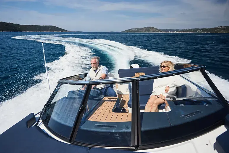 Parker 780 Escape navegando, vista frontal exterior con dos personas en la bañera y estela de agua trasera
