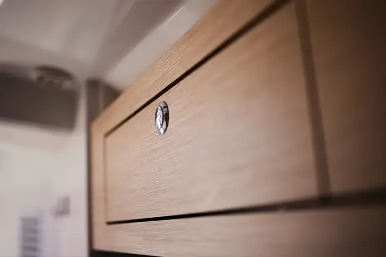 Interior del Parker 780 Escape, detalle de un armario de madera con cierre circular.