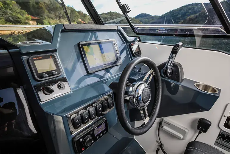Innensteuerstand des Parker 790 Explorer mit Lenkrad, Bildschirmen, Bedienelementen und Blick auf die Landschaft im Außenbereich