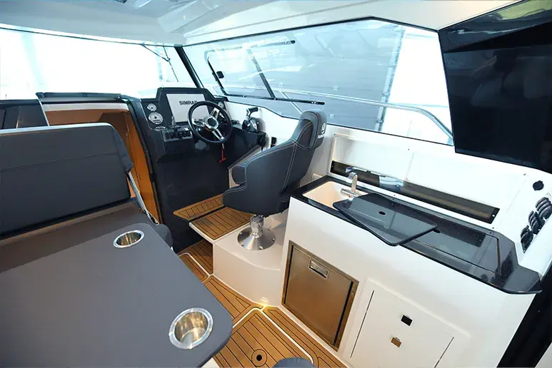 Innenraum der Parker 790 Explorer vom Heck aus gesehen, mit Steuerstand, Sitzen, Tisch und Pantry.