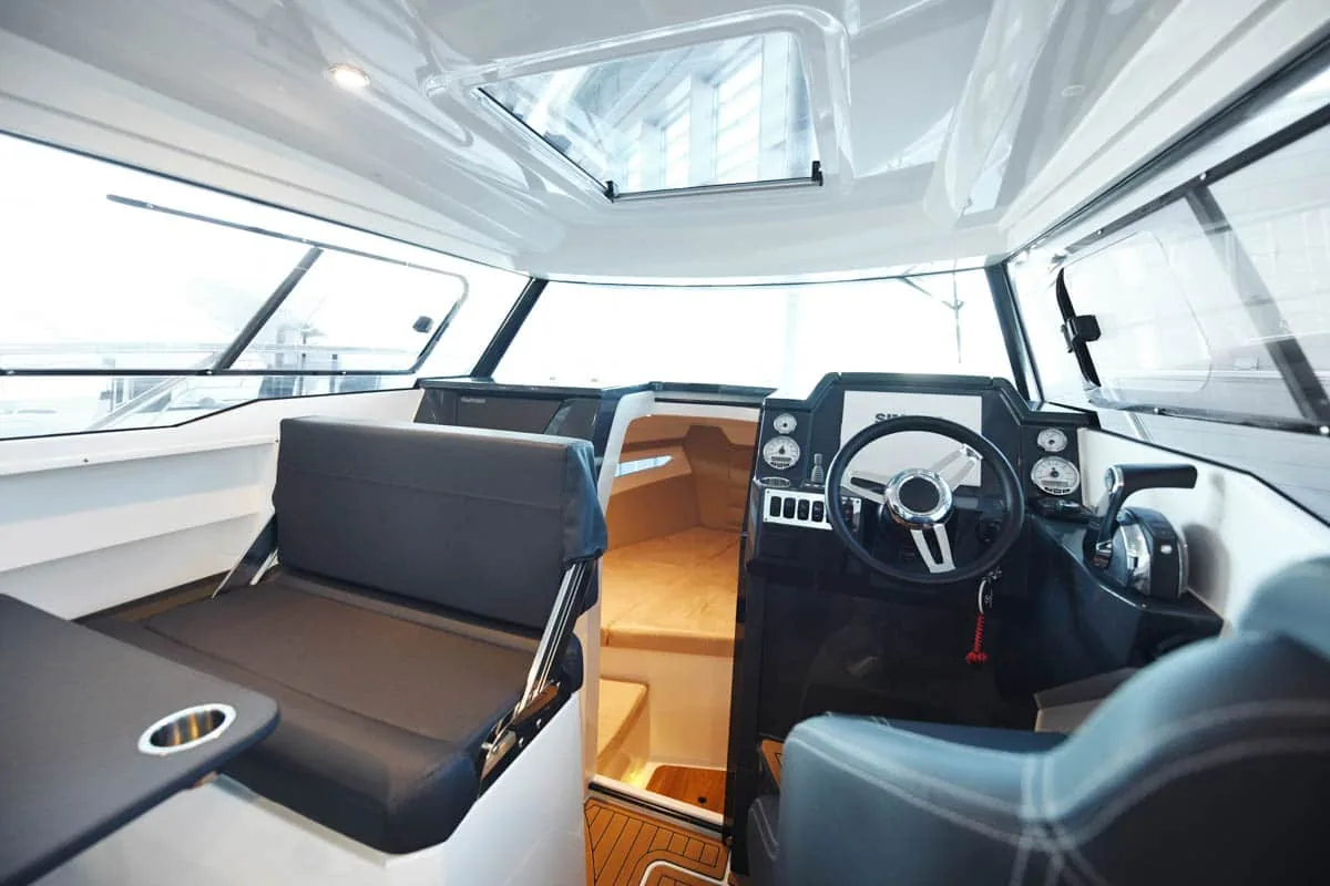 p790-GALERIE-22 Innenraum der Parker 790 Explorer vom Heck aus gesehen, mit Steuerstand, Lenkrad, Sitzen und Zugang zur Kabine.
